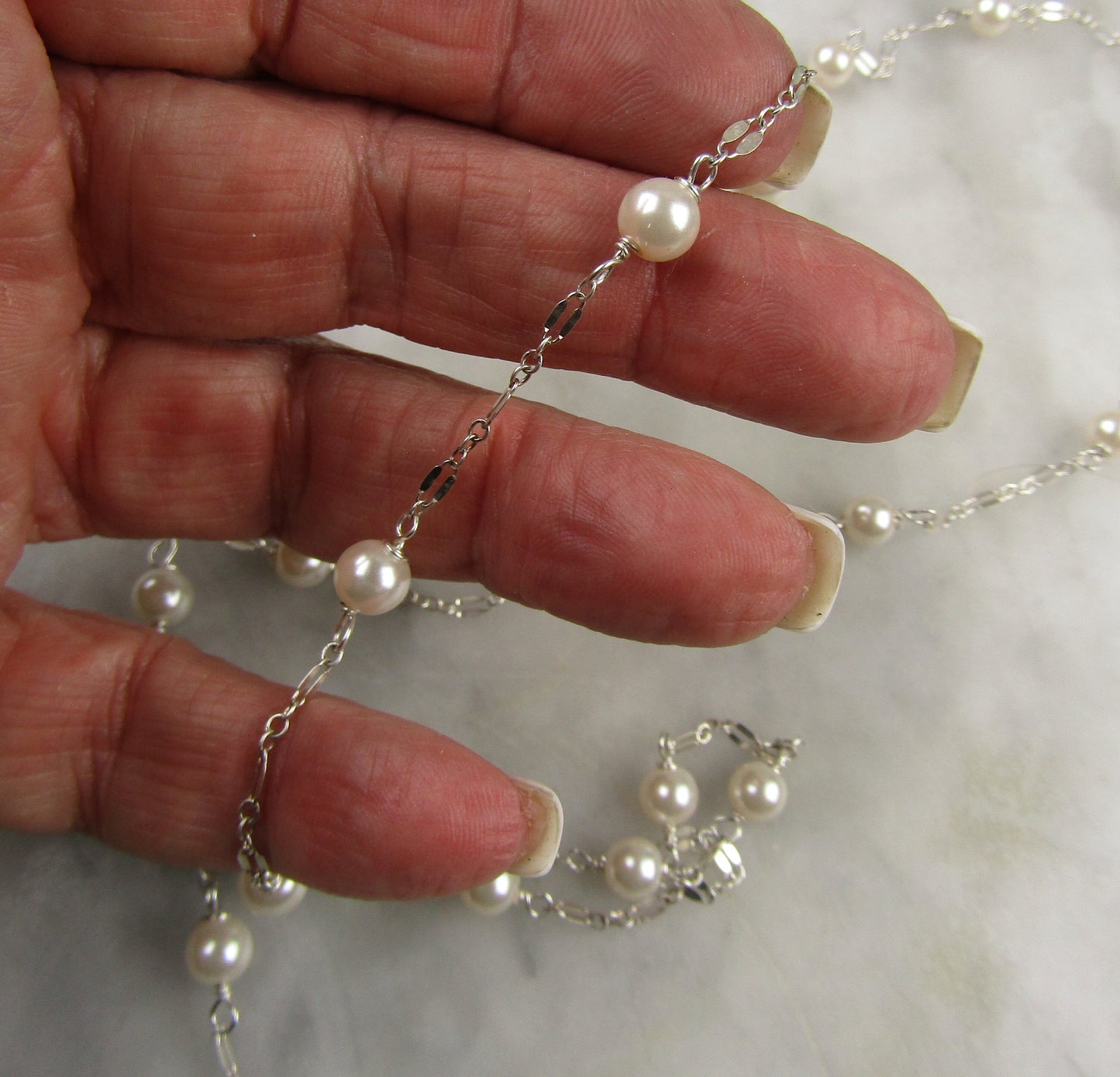 Long delicate sterling silver and pearl necklace, the necklace is 50 inches longwith a sterling silver magnetic clasp closure